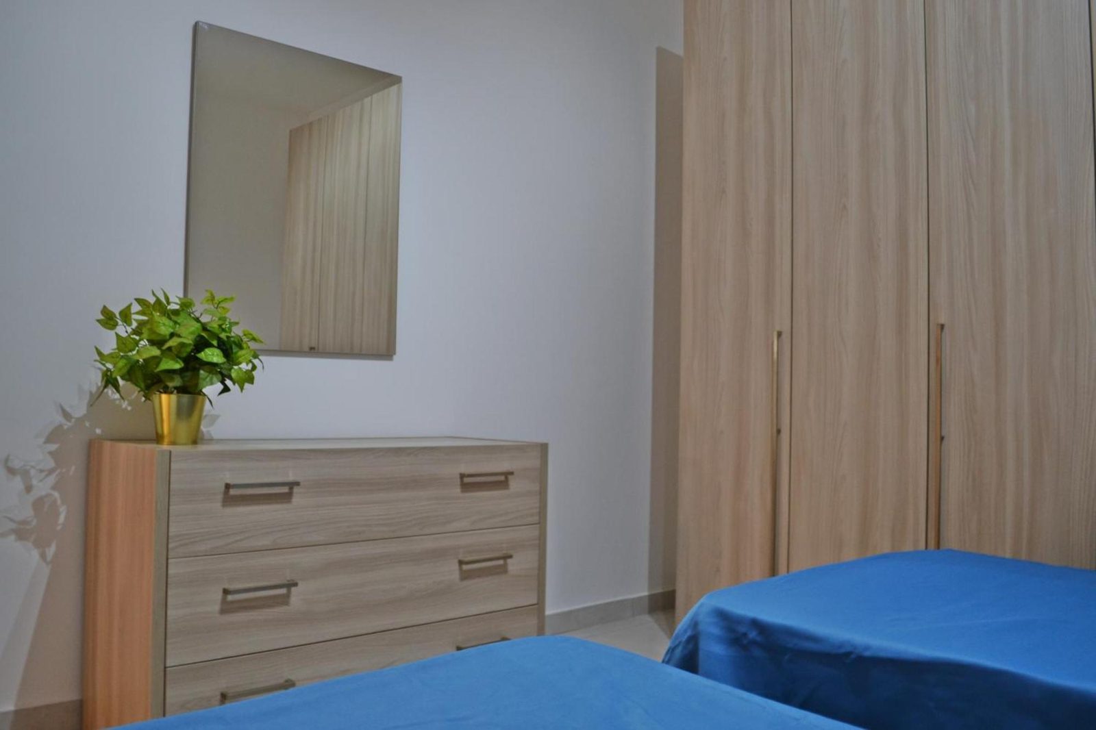 Bedroom detail with chest of drawers, mirror and house plant