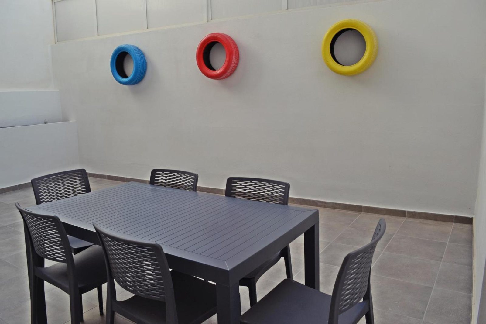Courtyard wall with colourful tyre planters