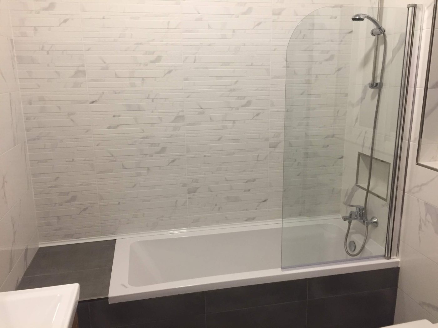 Shower over bathtub with elegant curved glass screen